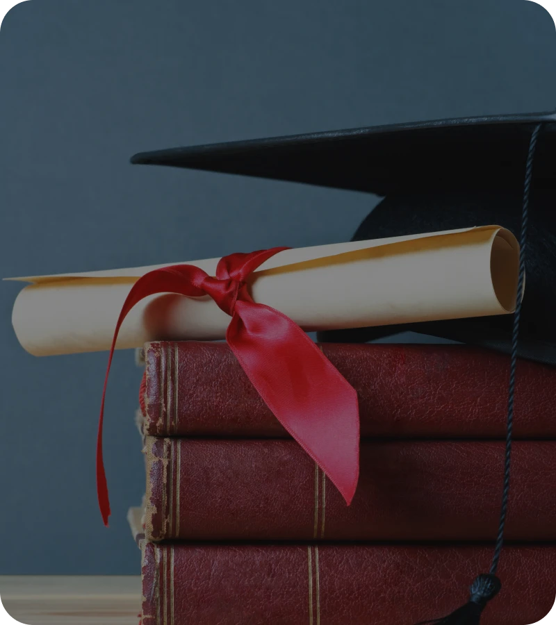 Graduation cap and diploma on books