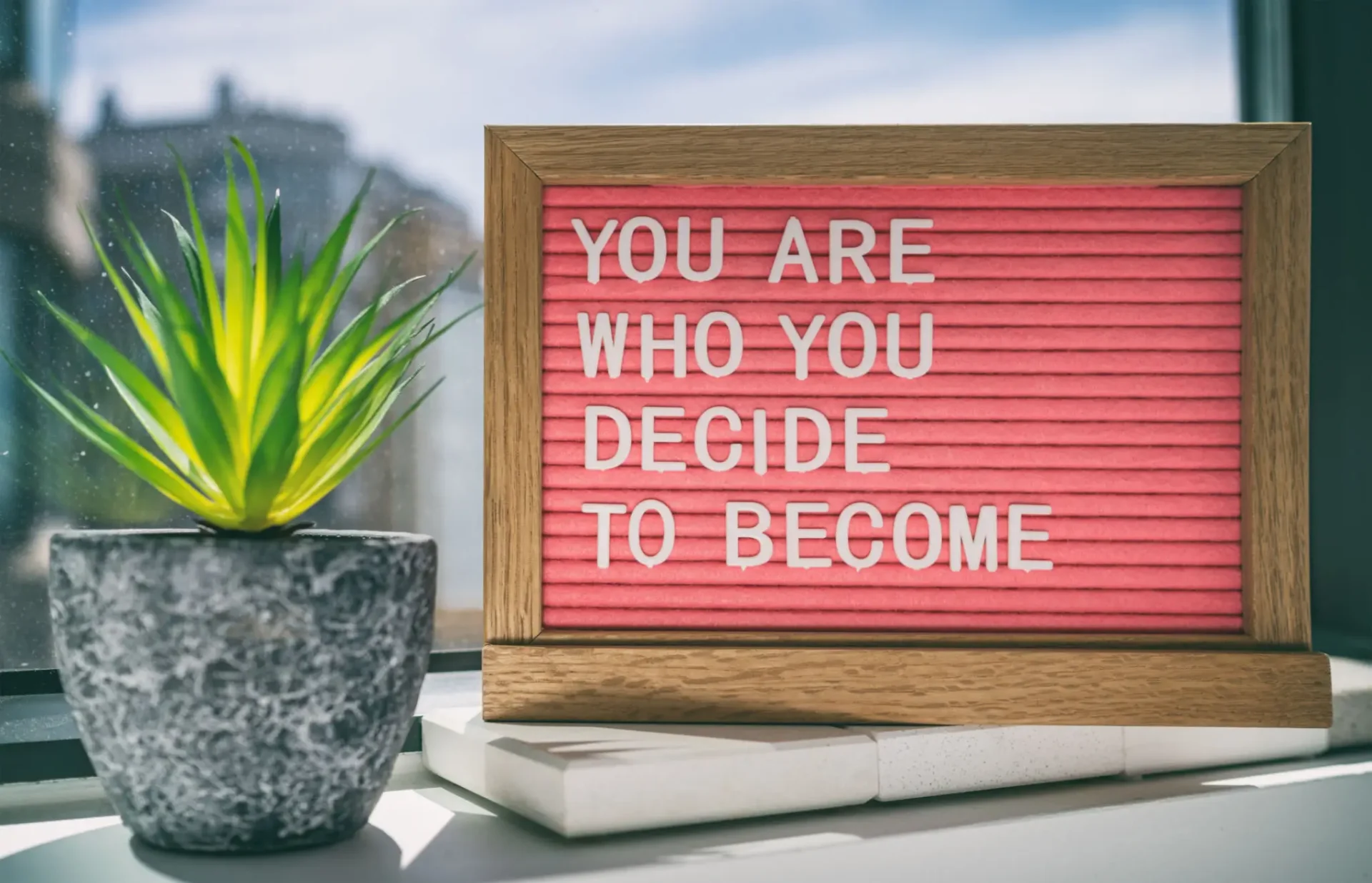 Motivational sign saying, 'You are who you decide to become.'